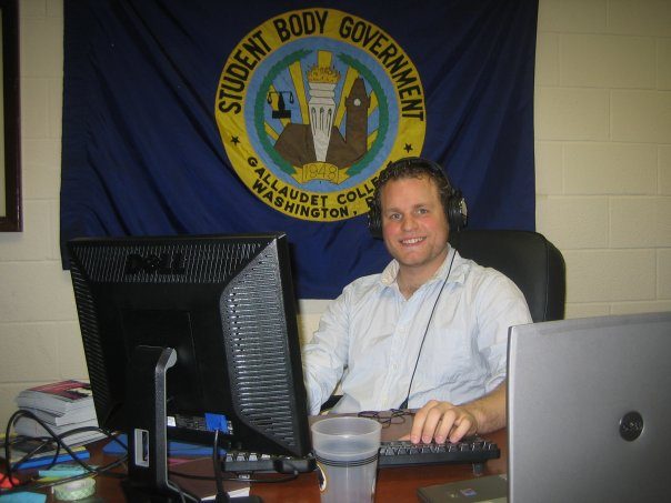 Robert McConnell seated at a desk in the Gallaudet Student Body Government office.